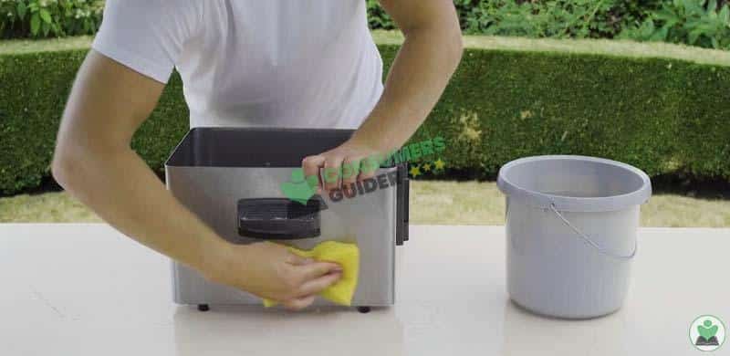 cleaning oil container of deep fryer with wet sponge