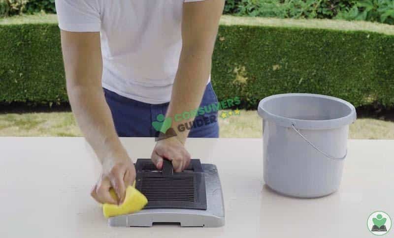 cleaning the lid of deep fryer with wet sponge
