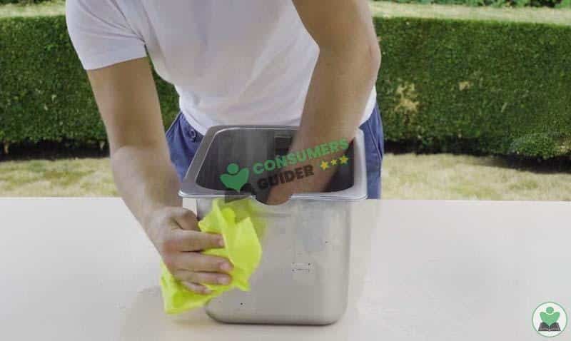 drying the oil container of deep fryer with paper towel