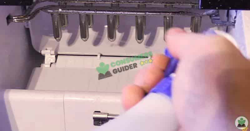 Spraying The Cleaning Solution Inside The Ice Maker To Clean It